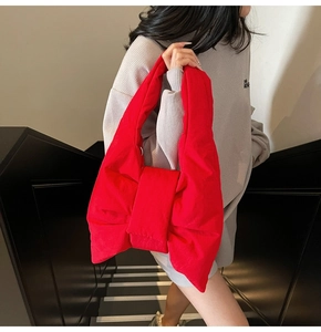 Macro detail of the oversized red bow shoulder bag crafted in puffy fabric material