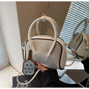 Detail of white PU leather bowling bag with black contrast piping and racquet pendant
