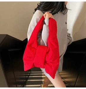 Detail of the oversized red bow-knot tote bag made of soft quilted fabric