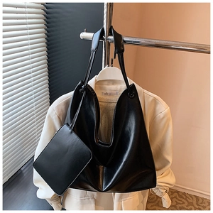 Detail of black large-capacity tote bag and matching inner pouch in premium PU leather