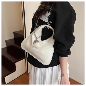 Detail of cream pleated crossbody bag with silver chain and 3D heart charm