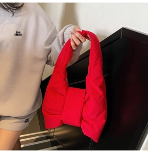 Detail shot of the red bow-shaped quilted tote bag featuring padded nylon texture and bold style