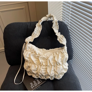 Minimalist cream white ruched yoga tote bag with cloud-like texture on a black chair