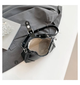 Detailansicht der Innenfütterung und silbernen Nieten einer schwarzen glänzenden Handtasche