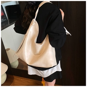 Minimalist beige leather shoulder bag with elegant knot detail on the strap