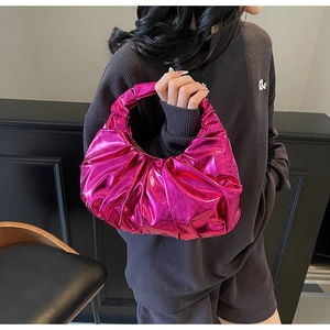 Detail of fuchsia metallic hobo bag with pleated texture and bright glossy finish