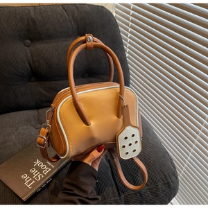 Close-up of caramel leather bowling bag with blue contrast edges and silver hardware