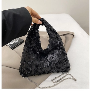 Close-up of black sequin handbag with silver metal chain strap on minimalist background