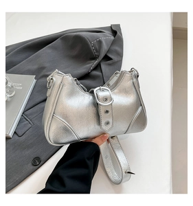 Detail der silbernen Metallic-Punk-Tasche mit Nieten und breitem Schnallenriemen