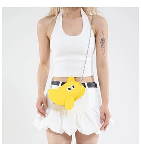 Detailed close-up of a vibrant yellow elephant-shaped crossbody bag with a silver chain