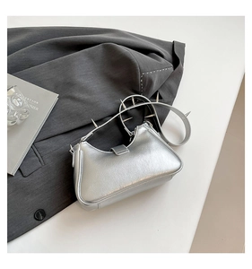 Detail der silbernen Metallic-Schultertasche mit Punk-Nieten am Schultergurt