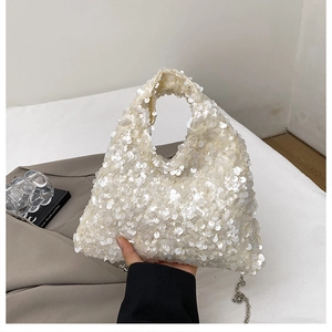Detail shot of the triangular sequin handbag with a silver metal chain strap