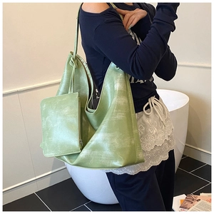 Detail of green hobo tote bag with vintage washed texture and matching zipper pouch