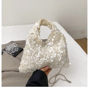 Detailed view of cream sequin handbag with metallic chain strap and circular top handle
