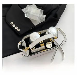 Interior view of white leather crossbody bag showing capacity for phone and cosmetics