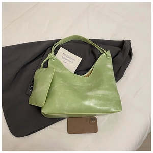 Detail of light green hobo bag with vintage washed texture and knotted shoulder strap