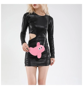 Detail shot of a pink cartoon crossbody bag paired with a black snakeskin dress