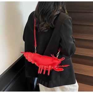 Detailed view of creative red lobster crossbody bag with gold rivets and adjustable strap