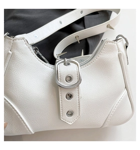 Nahaufnahme der weißen PU-Ledertasche mit Falten, Silberschnallen und Punk-Nieten
