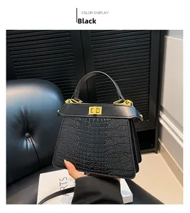 Detailed view of black crocodile pattern handbag featuring a gold twist lock and handle
