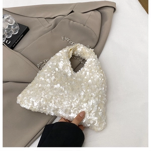 Detail of white sequin handbag featuring a metallic chain strap and fish-scale texture