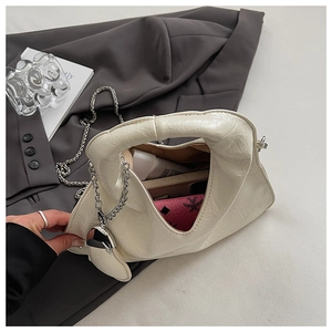 Detail of creamy pleated crossbody bag showing spacious interior with silver chain