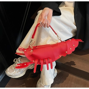Detailed close-up of a creative red lobster-shaped handbag with gold rivet accents