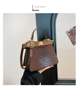 Detailed close-up of brown crocodile pattern handbag with golden metal turn-lock closure