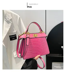 Detail of pink crocodile embossed leather handbag with elegant gold twist lock closure