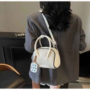 Detailed back view of a white bowling bag with black trim on a gray blazer