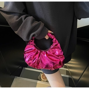 Detail of metallic rose red pleated handbag with stylish ruched texture and top handle