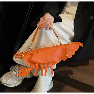 Detailed view of an orange lobster-shaped PU leather handbag with gold rivets and zippers
