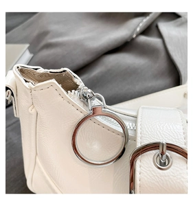 Detailansicht der elfenbeinfarbenen Umhängetasche aus Kunstleder mit silbernem Ring-Zipper