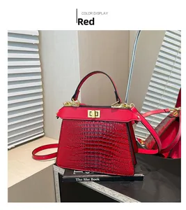 Detail of red crocodile embossed kelly bag featuring gold twist lock and shoulder strap