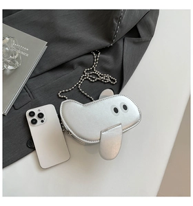 Close-up of funny silver cartoon crossbody bag with metallic finish and metal chain strap