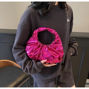 Detailed view of shiny metallic pink pleated handbag with modern half-moon design