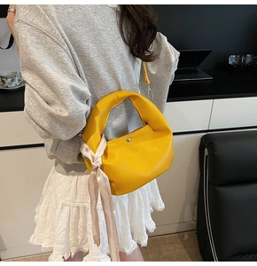 Chic yellow lychee leather handbag with floral silk scarf on model in lifestyle setting