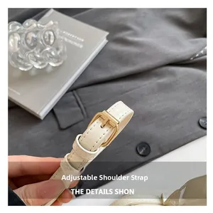 Detail of adjustable white leather shoulder strap with gold buckle for shell bags