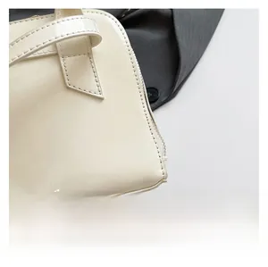 Detailed macro view of high-gloss white patent leather stitching and zipper on pillow bag