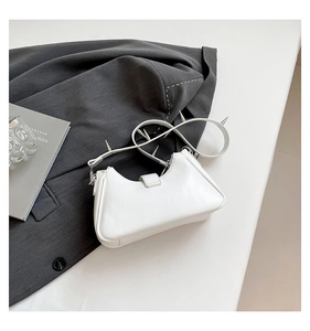 Nahaufnahme der weißen Punk-Tasche mit silbernen Metallstacheln am Schultergurt