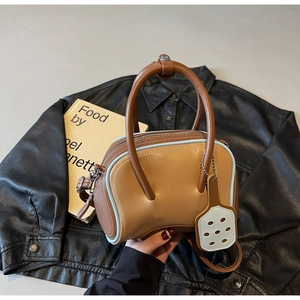 Detail of two-tone leather bowling bag with brown body and blue trim accents