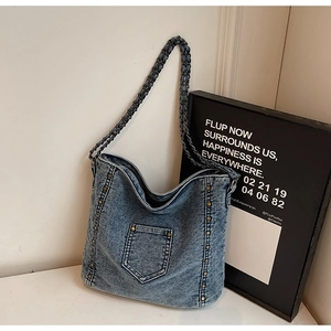 Λεπτομέρεια vintage τσάντας denim με μεταλλικά πριτσίνια και λουράκι ώμου αλυσίδα