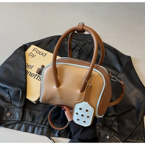 Close-up of contrast color bowling bag in brown and blue with top handle and strap