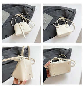 Detailed views of creamy white patent leather shell bag with gold base studs and top handle