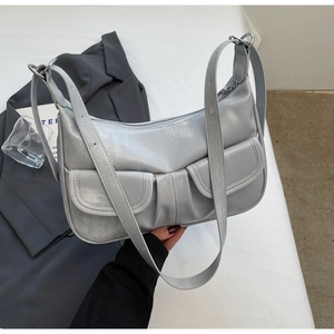 Detail of silver metallic hobo bag with double front pockets and adjustable strap