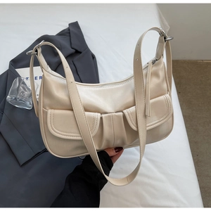 Detail of minimalist beige half-moon hobo bag with twin front pockets and lychee texture