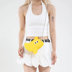 Cute yellow elephant mini crossbody bag with silver chain strap on a white dress