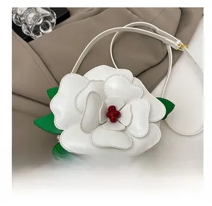 Detail showing 3D white flower petal bag with green leaves and pearl accents