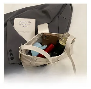 Spacious interior of off-white rivet handbag showing phone, perfume and lipstick