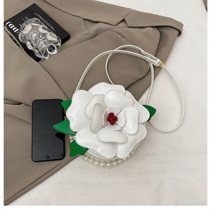 Detail of camellia shaped floral bag with white petals, red core and pearl trim edge